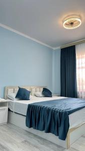 Un dormitorio con una cama grande con sábanas azules. en Safo Guest House, en Khiva