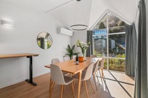 a dining room with a wooden table and chairs at Urban Oasis - Central with Lakeview in Queenstown