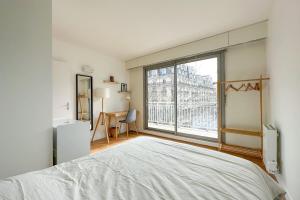 Un dormitorio con una cama y una ventana grande. en Flexliving - room - Ternes, en París