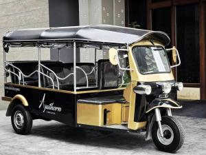 ein kleiner gelber und schwarzer Wagen mit Motorrad in der Unterkunft Ayathorn Bangkok in Bangkok
