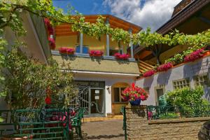 a house with flowers on the balconies and plants at Moselstern Hotel Zum guten Onkel in Bruttig-Fankel