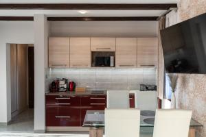 a kitchen with wooden cabinets and a table with chairs at Villa Garden in Zalaegerszeg +37 photos