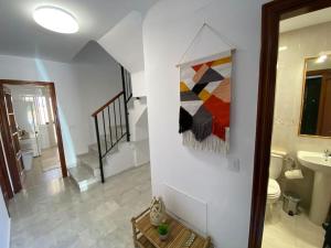 een badkamer met een wastafel en een schilderij aan de muur bij Dúplex Romero y Alba in Sanlúcar de Barrameda +42 foto's