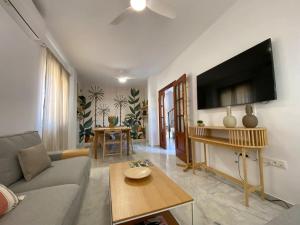 een woonkamer met een bank en een flatscreen-tv bij Dúplex Romero y Alba in Sanlúcar de Barrameda