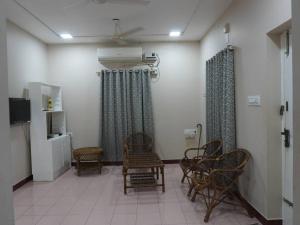 a waiting room with chairs and a tv and curtains at Ess Emm Farms in Vasavasamudram