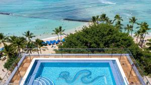 a swimming pool with a view of a beach at ESPACIO THE JEWEL OF WAIKIKI in Honolulu