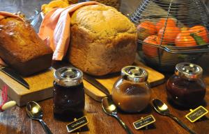 stół z bochenkiem chleba, dżemem i łyżkami w obiekcie Terres de la Grange w mieście Cuisiat