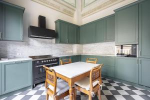 Una cocina con gabinetes verdes y una mesa y sillas. en Albizi Penthouse Luxury Apartment In Florence By Palazzo Pazzi Vitali, en Florencia 29 fotos más