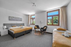 a bedroom with two beds and a chair at Hotel PODKOST in Libošovice
