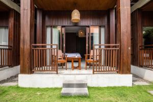 un porche d'une maison avec des chaises et une table dans l'établissement Cove Dadeka, à Canggu