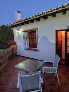 een terras met een tafel en stoelen en een huis bij Casa Villazo II in Almáchar