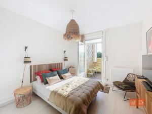 een slaapkamer met een bed en een groot raam bij Le Mourillon - Centre Ville in Wimereux