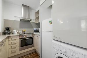a kitchen with a white refrigerator and a dishwasher at Family-Friendly Andorra Accommodation - Happy Rentals in El Tarter