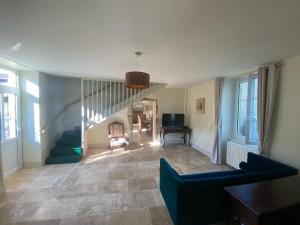 Una sala de estar con una escalera y un sofá. en Grande maison avec super vue, en Saint-Benin-dʼAzy
