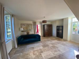 sala de estar con sofá azul y ventanas en Grande maison avec super vue, en Saint-Benin-dʼAzy