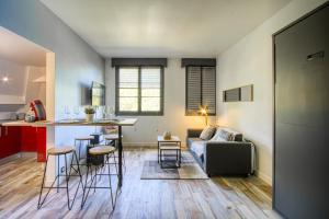 a living room and kitchen with a couch and a table at L'atelier de Barbizon - Studio in Barbizon