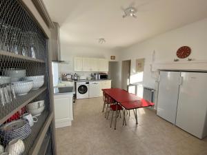 cocina con mesa roja y encimera roja en Grande maison avec super vue, en Saint-Benin-dʼAzy