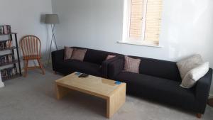 un soggiorno con un divano nero e un tavolino da caffè di 3 bed house Market Deeping - Peterborough, Stamford, Spalding a Market Deeping