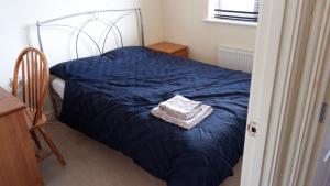 una camera da letto con un letto con un piumone blu di 3 bed house Market Deeping - Peterborough, Stamford, Spalding a Market Deeping