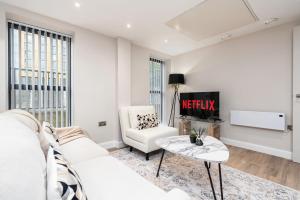 a living room with a white couch and a tv at Luxury One Bedroom Apartment - City Centre - Free Wifi Netflix in Leeds