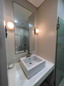 a white bathroom with a sink and a mirror at Miranda B 319 at Pico de Loro by Raquels Place in Nasugbu