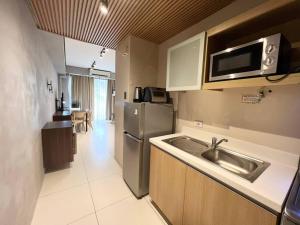 a kitchen with a sink and a stainless steel refrigerator at Miranda B 319 at Pico de Loro by Raquels Place in Nasugbu