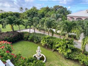 an aerial view of a garden with palm trees and a house at Holland Park Barbados in Saint Peter