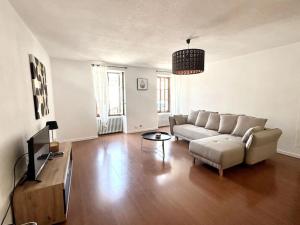 una sala de estar con un sofá y una mesa en Appartement Spacieux et Lumineux Proche Valence, en Saint-Péray