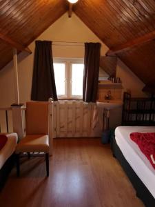 a attic bedroom with a bed and a window at De Stormmeeuw in Egmond aan Zee