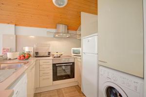 a kitchen with a white refrigerator and a dishwasher at Andorra Family Snow Apartment - Happy Rentals in El Tarter