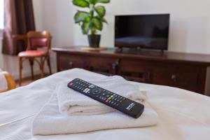 ケムニッツにあるGästezimmer I Einzelzimmer mit Gemeinschaftsbad und Gemeinschaftsküche Chemnitzのベッドの上のタオルの山の上に置かれたリモコン