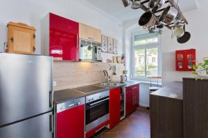 ケムニッツにあるGästezimmer I Einzelzimmer mit Gemeinschaftsbad und Gemeinschaftsküche Chemnitzの赤いキャビネットとステンレス製の冷蔵庫を備えたキッチン +2枚の写真