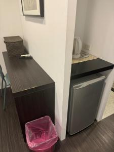 a kitchen with a counter and a small refrigerator at Taipei Breeze Guesthouse in Taipei