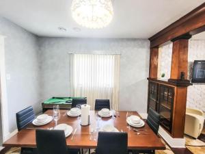 a dining room with a table with chairs and a pool table at 10 Mins to Airport Apt with King Beds in Buffalo +10 photos