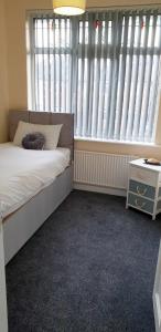 a bedroom with a bed and a large window at House in Wollaton, Nottingham in Nottingham +4 photos