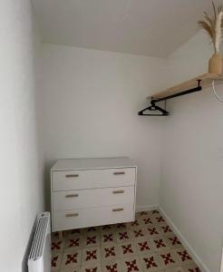 a bedroom with a dresser and a shelf on the wall at Maisonnette à Arago in Les Sables-d'Olonne +8 photos