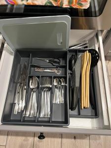 a drawer in a refrigerator filled with utensils at Ozas Park Apartments in Vilnius