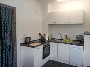 a kitchen with white cabinets and a stove top oven at gemütliche Unterkunft II in Bretsch