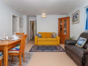 a living room with a yellow couch and a table at Brixham Breeze Cabin in Brixham