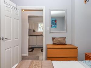 a bedroom with a bed and a table and a mirror at Brixham Breeze Cabin in Brixham
