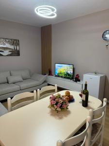 a living room with a table with flowers and a couch at Nefis Apartament in Berat