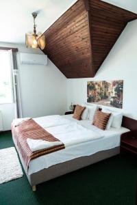 A bed or beds in a room at Bagoly Fogadó
