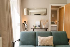 a living room with a blue couch and a mirror at Fieldside Cottage in Scarborough +34 photos