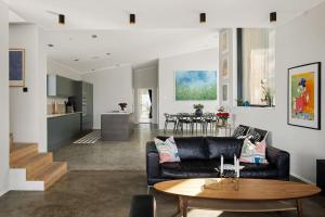 a living room with a couch and a table at Exklusiv villa med pool & fri havsutsikt in Sommarbo