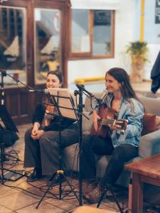 a woman playing a guitar next to a microphone at Antarctica Hostel in Ushuaia