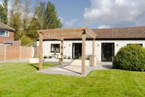 a wooden pergola in the backyard of a house at Fieldside Cottage in Scarborough