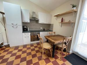 a kitchen with a table and chairs in a room at Maisonnette à Arago in Les Sables-d'Olonne