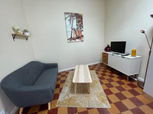 a living room with a blue chair and a coffee table at Maisonnette à Arago in Les Sables-d'Olonne