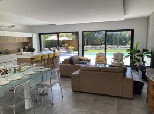 kuchnia i salon z kanapą i stołem w obiekcie Maison élégante à Bouc-Bel-Air avec piscine privée w mieście Bouc-Bel-Air