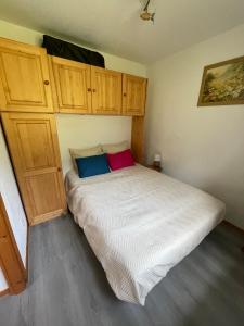 a bed in a bedroom with wooden cabinets at Appartement convivial à Thollon-les-Mémises, 35 m², vue montagne in Thollon